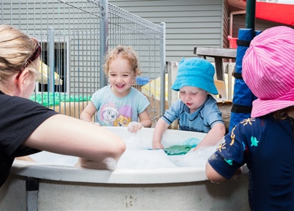 Early Childhood Teacher and Children in water play