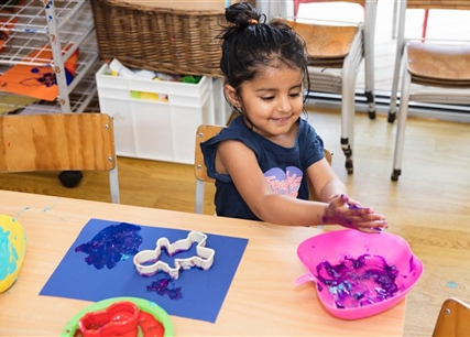 preschool child smiling and learning through messy play 